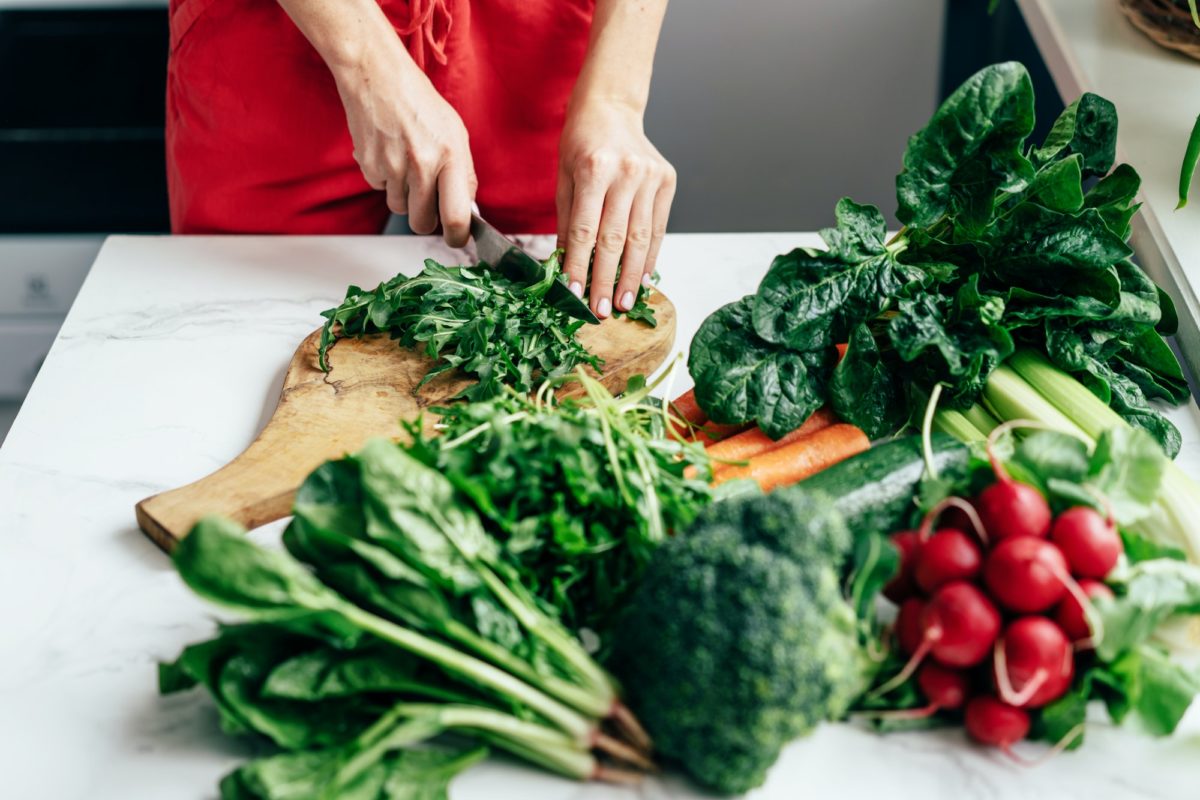 Female hands cut greens on a blackboard on a table. Cooking healthy food. Healthy lifestyle.